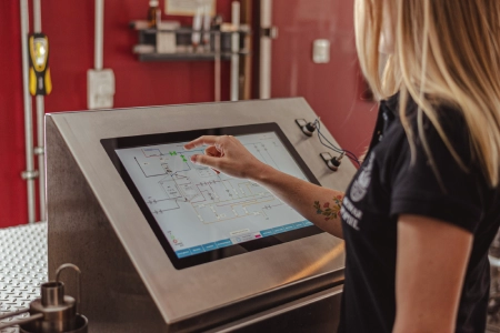 Pracownica browaru obsługująca cyfrowy system kontroli produkcji